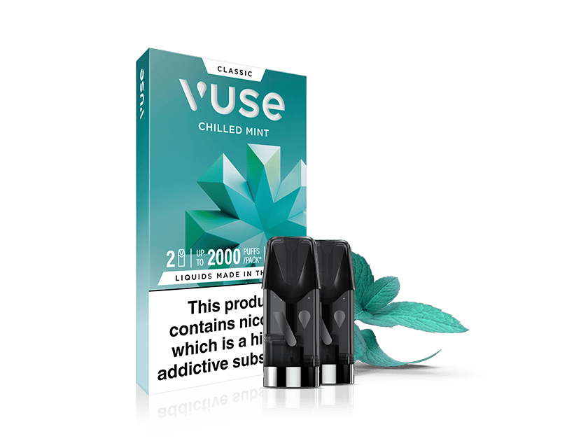 A Vuse Classic Chilled Mint vape pod pack is shown with three black vape pods in front of the box. A mint leaf is placed beside the pods. The packaging includes a nicotine warning label.