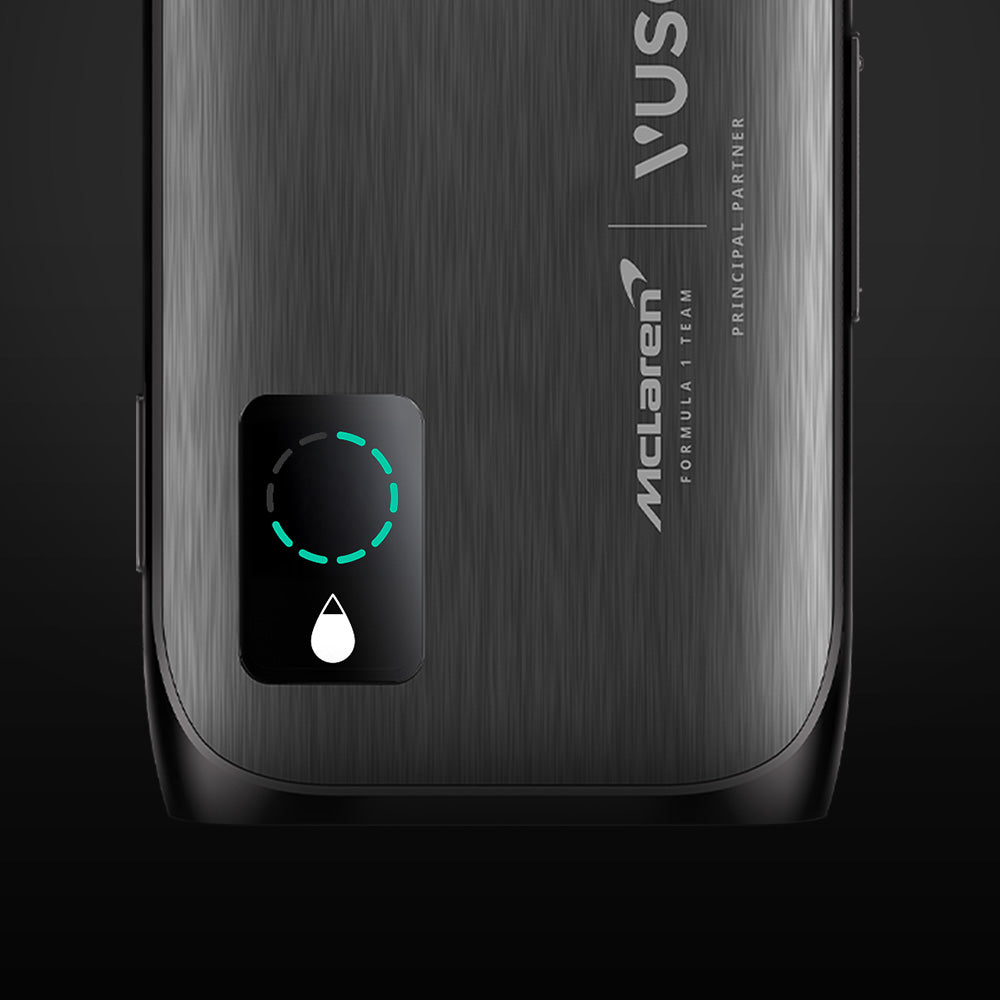 Close-up of a sleek, metallic device featuring McLaren branding and a black rectangular button with a glowing green outline and a white droplet icon, set against a dark background.