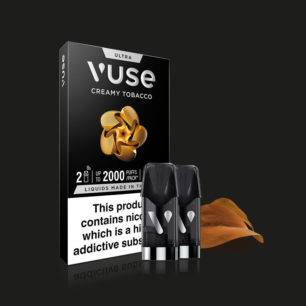 A Vuse Creamy Tobacco Ultra Smart Pod pack with two pods and a brown tobacco leaf is shown on a black background. The packaging notes "up to 2000 puffs," ceramic heater technology, and carries a nicotine warning label.