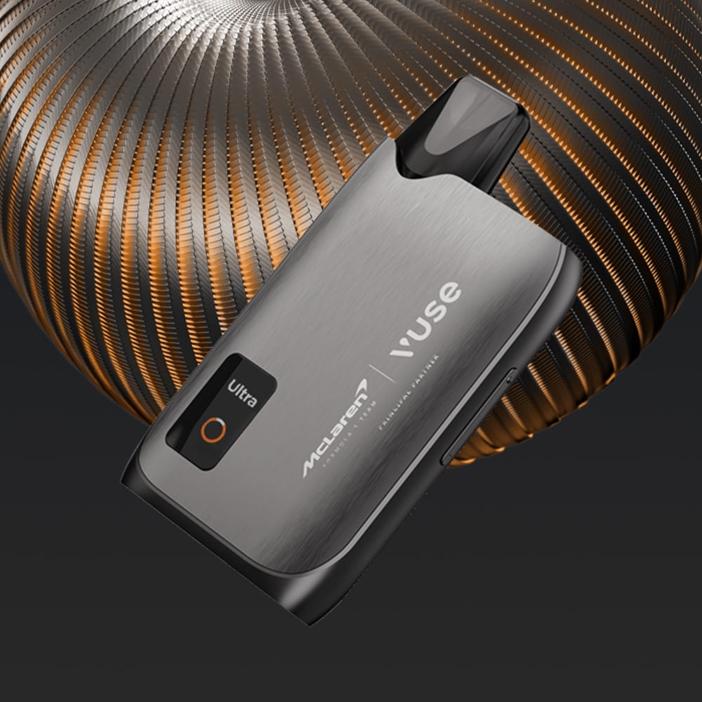 The Vuse Ultra Device Kit McLaren by Vuse, featuring a metallic finish and McLaren branding, is displayed against an abstract copper and black background that emphasizes the device’s sleek, modern design.
