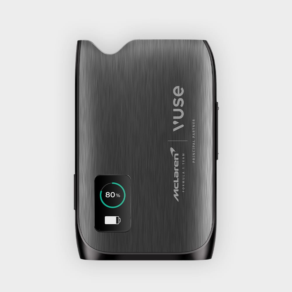 A sleek, metallic Vuse vape device with McLaren branding is shown from above. The device displays an 80% battery indicator on a small screen in the lower left corner. The surface has a brushed metal texture.