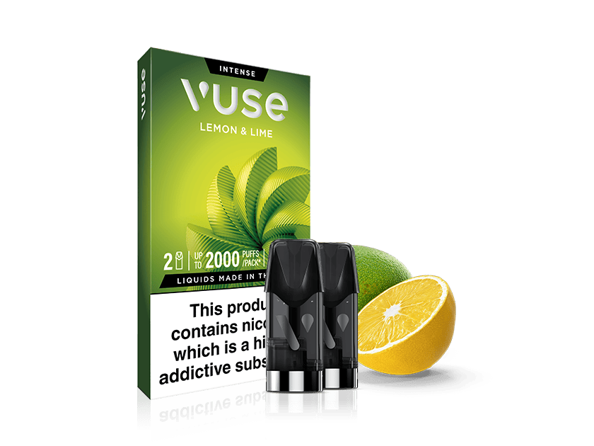 A Vuse Lemon & Lime vape cartridge box with three black cartridges in front, next to a halved lemon and a whole lime. The box displays health warnings about nicotine.